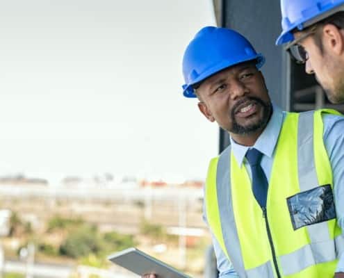 Construction workers discussing blueprint
